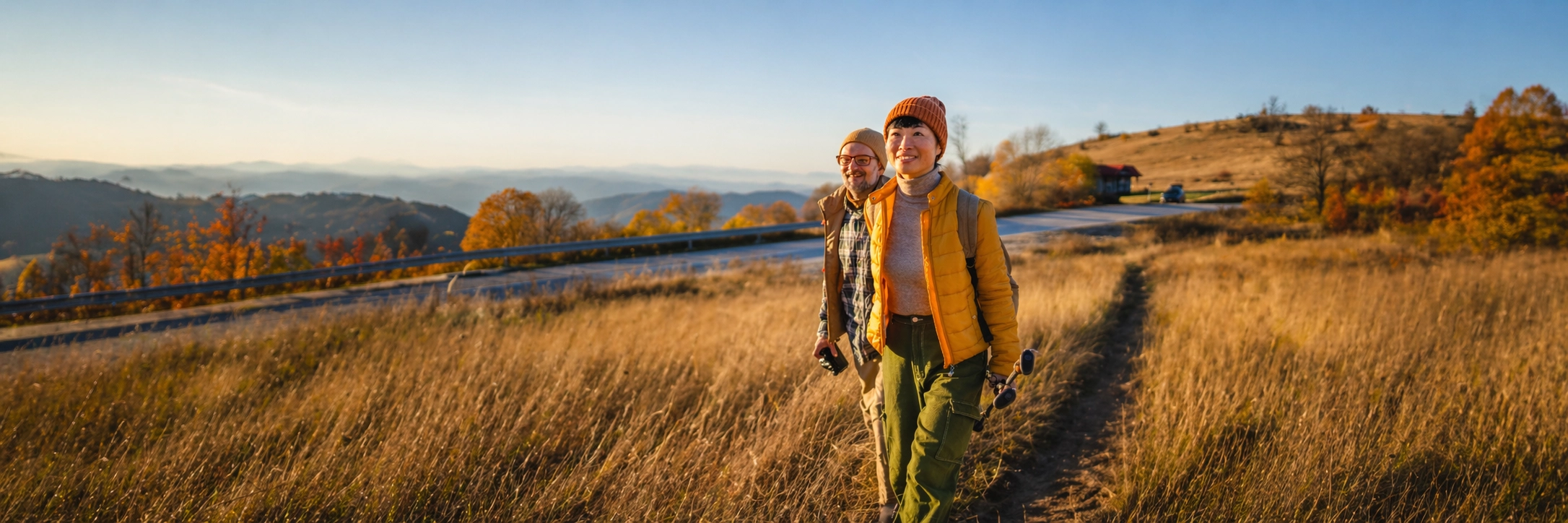 A couple hiking together through golden autumn hills